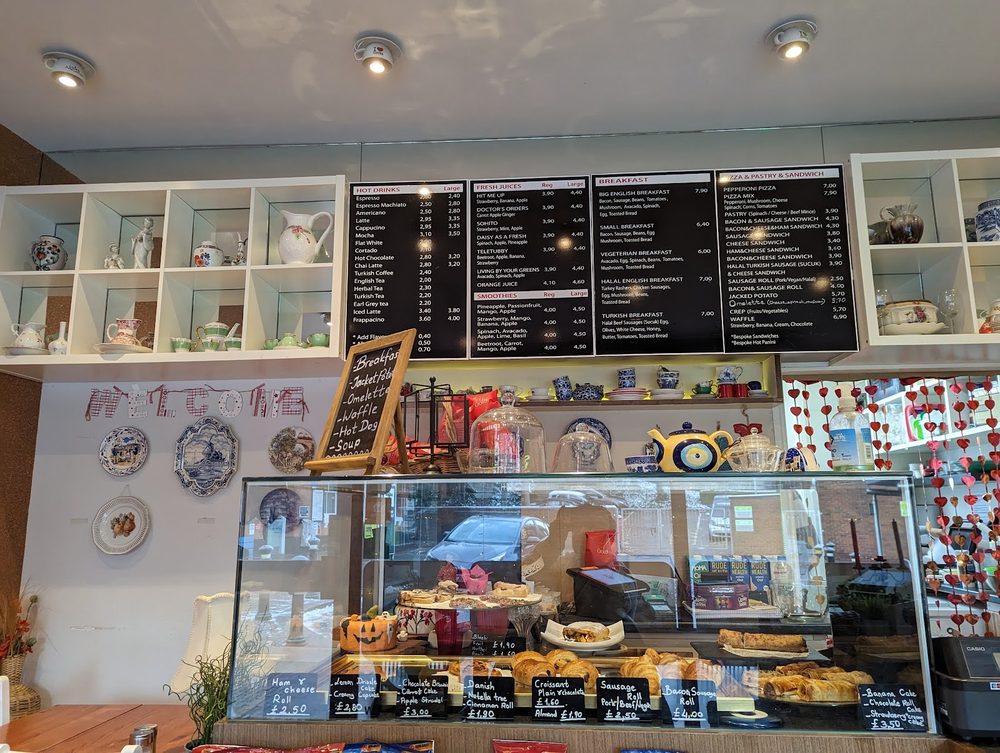The cafe counter and serving area with a glass display of cakes and pastries