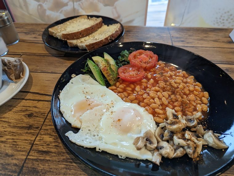 Full English breakfast on a black plate